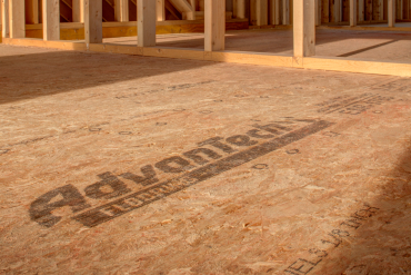 AdvanTech subfloor panel with visible branding stamp installed at a residential construction site.