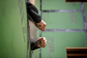 Close-up of hands pressing ZIP System stretch tape into place along an exterior wall corner.